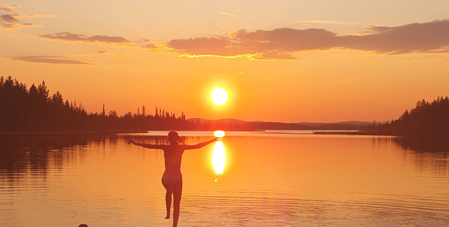 Badande på en brygga i kvällssol